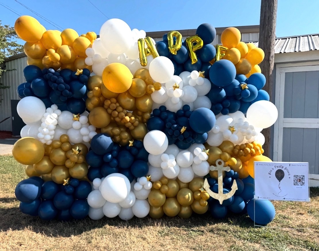 Navy, white and gold balloon wall spelling HOPE with anchor accent